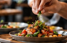 Manos de chef terminando un plato en un restaurante